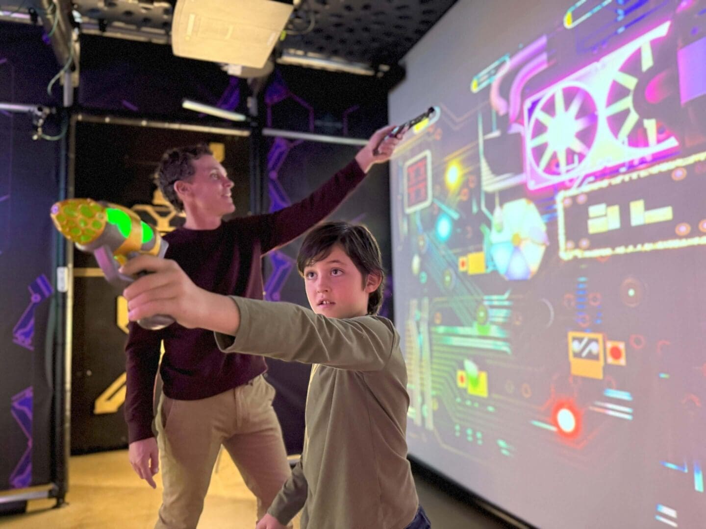 Two people playing with interactive light guns.