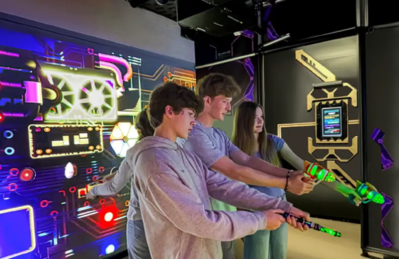 Teens playing laser tag in futuristic arena.