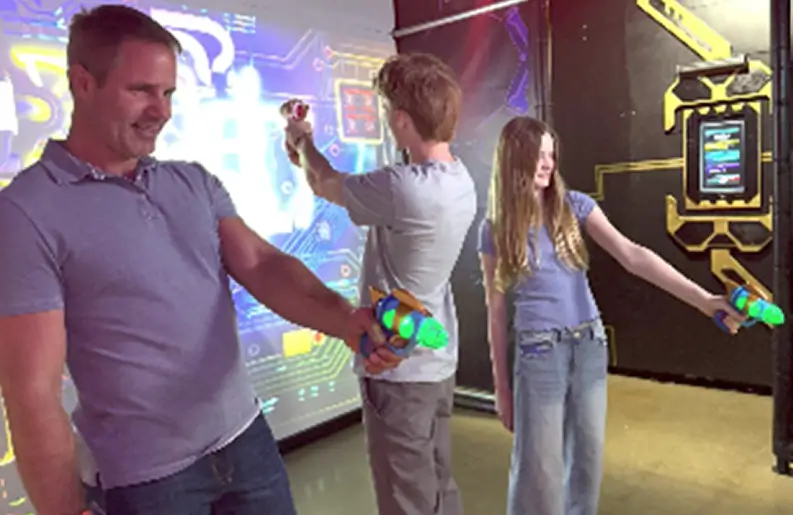 People playing interactive laser tag game indoors.